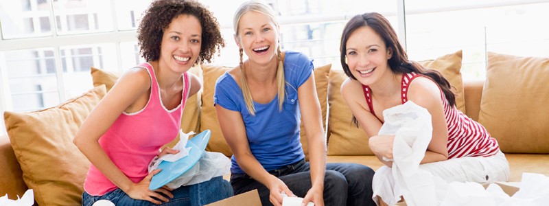 three roommates are sitting on a couch