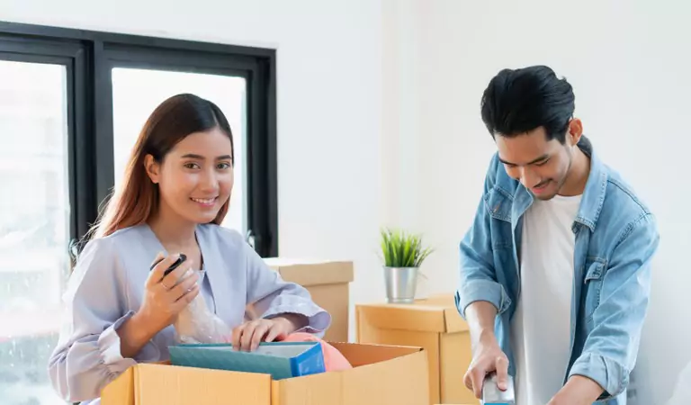 couple unpacking a box and looking very happy