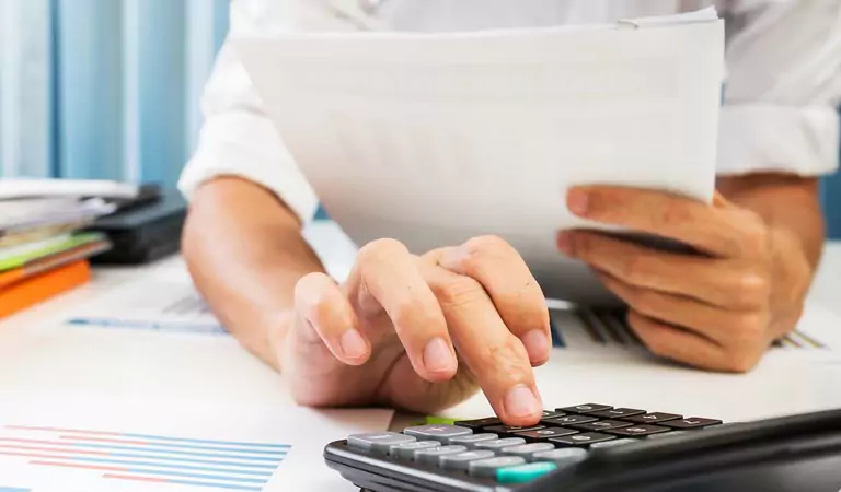 cropped picture of a person calculating something on a calculator