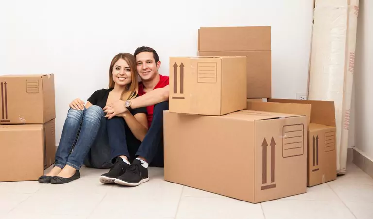 couple sitting on a corner with some boxes