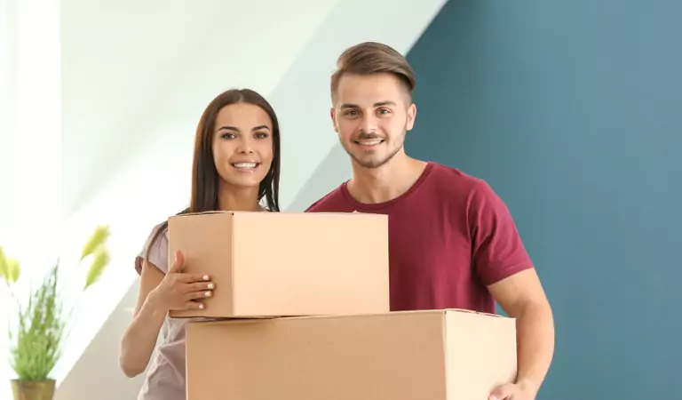 beautiful couple with a couple of boxes inside of a house