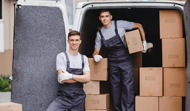professionals loading a van with cardboard boxes