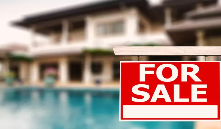 board writter for sale on it and house at the background