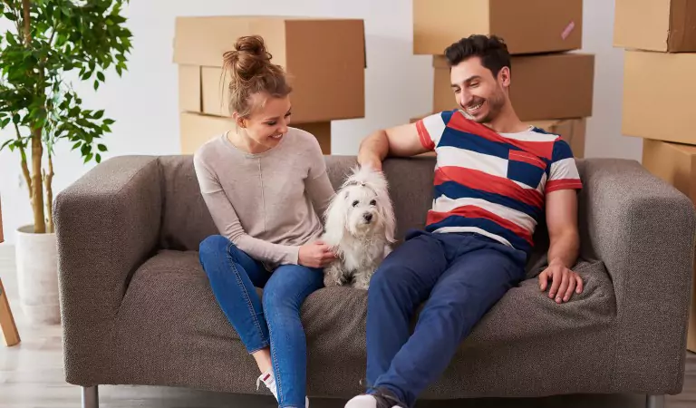 couple sitting with their pet on a couch