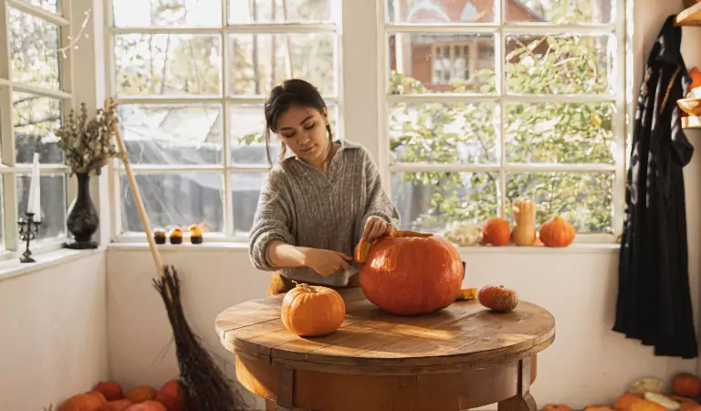 woman carving a pumpkin for halloween