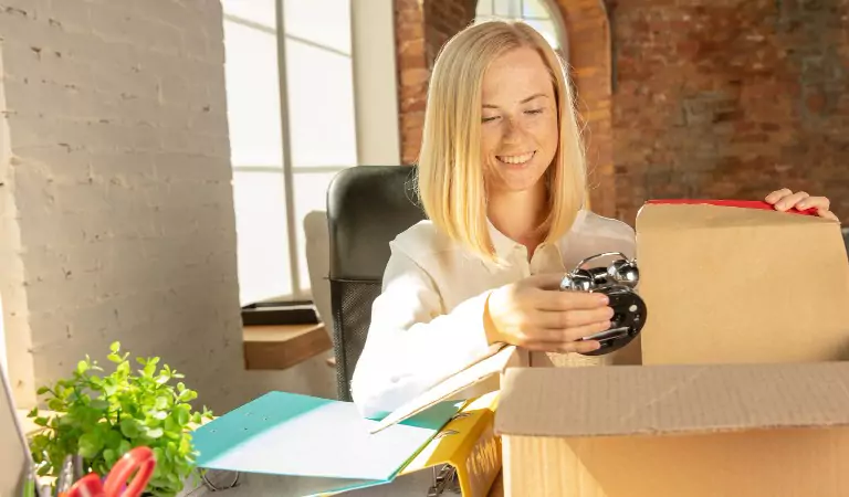 young woman packing her office belongings into a box
