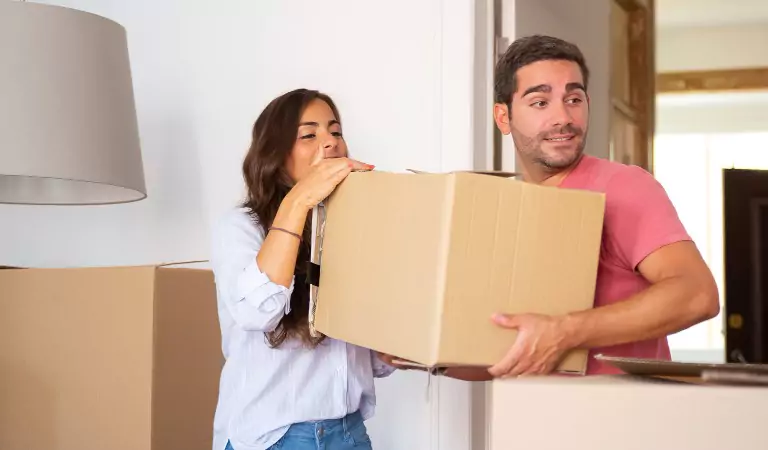 couple inside of a house with some boxes