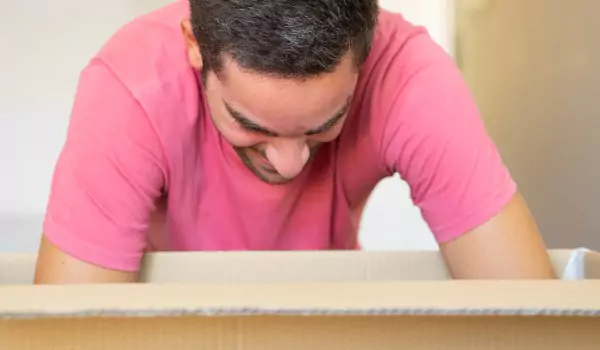 young man unpacking a cardboard box